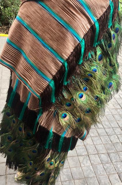 Rebozo artesanal cafe con lineas verdes y plumas de pavorreal decorando las puntas