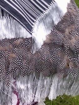 Rebozo artesanal negro rayado con plumas de gallina de guinea decorando las puntas